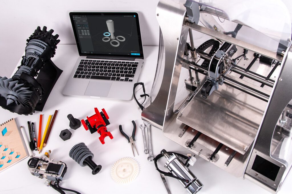 3D-Drucker auf dem Schreibtisch mit diversen gedruckten Teilen